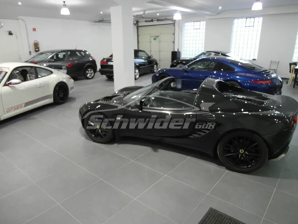 Halle mit mehreren Porsche-Modellen