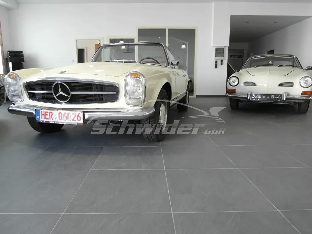 Mercedes 280 SL Pagode neben einem Karmann Ghia in der Halle